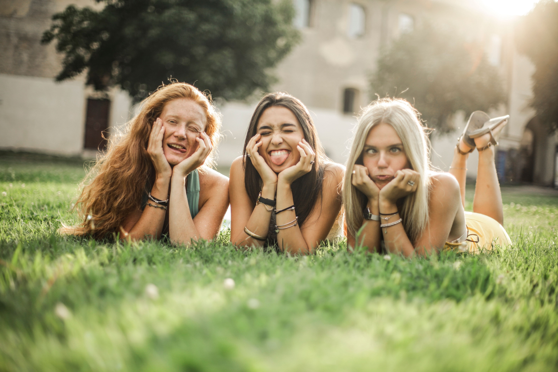 Instagram account verwijderen, drie vriendinnen liggen lachend in het gras zonder telefoon
