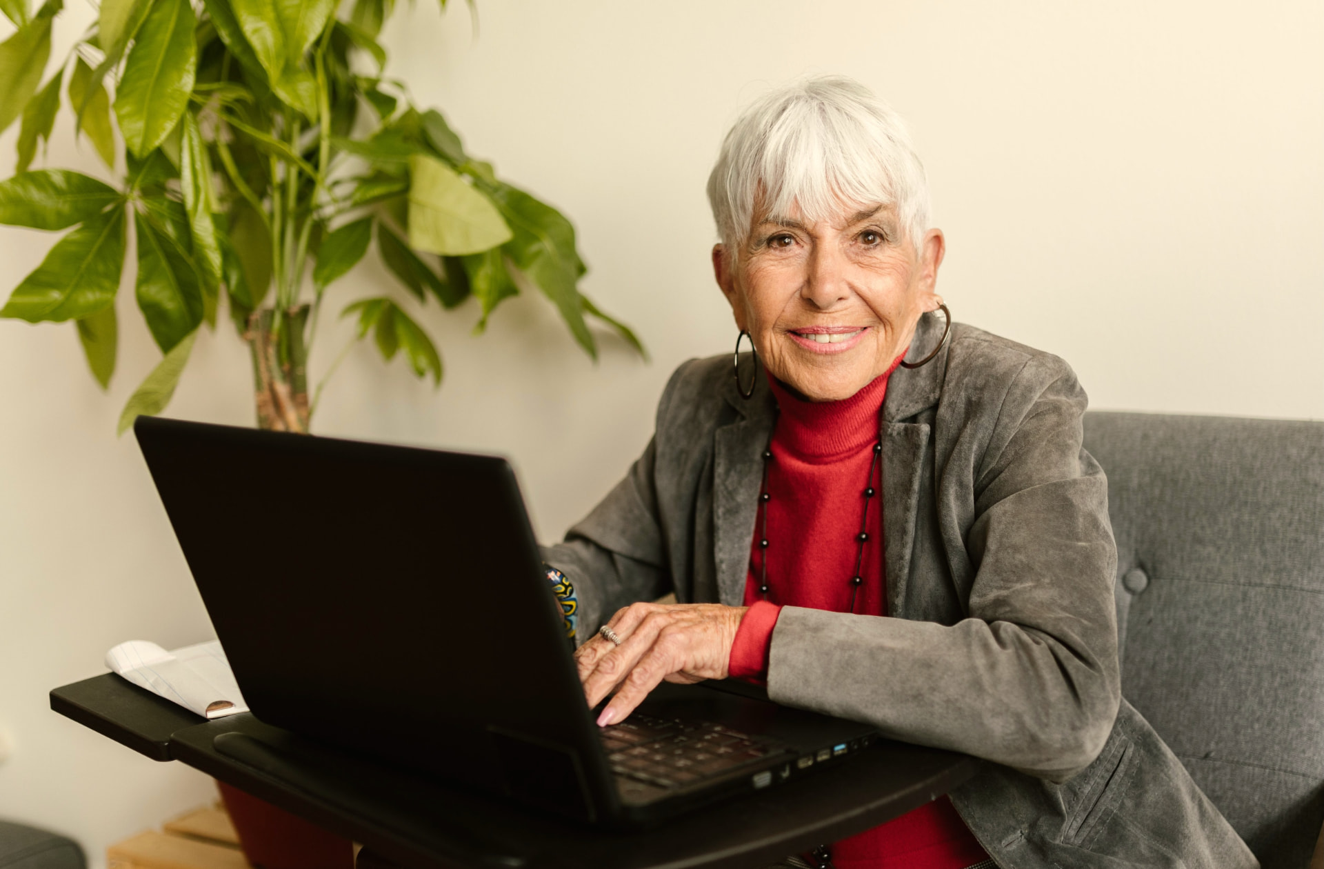 Oudere vrouw regelt haar digitale zaken op een laptop, symboliseert het bij leven regelen van een digitale nalatenschap